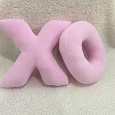 a pink stuffed animal with the letter x on it