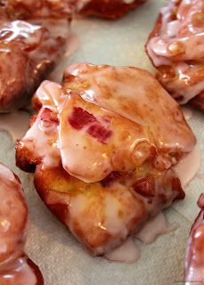 some kind of pastry with icing on it sitting on a piece of parchment paper