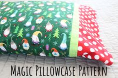 a green pillow with gnomes and christmas trees on it, sitting on a bed