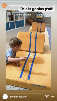 a little boy that is laying down on some kind of mattresses with blue tape