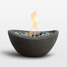 an outdoor fire pit with rocks in the center and flames coming out of it's sides