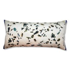 a white and blue rectangular pillow with insects on the front, sitting on a white surface