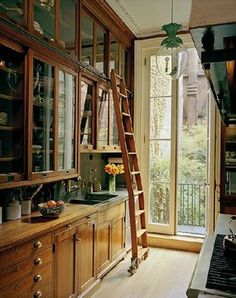 the ladder is leaning up against the wall in the kitchen, leading to the window