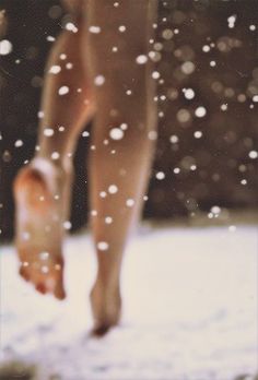 a person walking in the snow with their bare legs