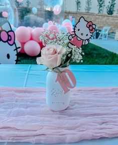 a hello kitty themed birthday party with pink and white flowers in a mason jar filled with baby's breath