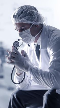 a male doctor in a white shirt is holding a stethoscope