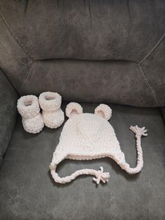 a crocheted hat and booties are on the couch