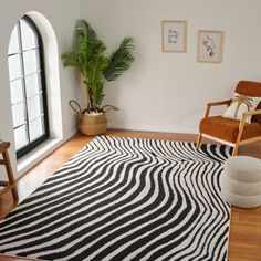 a living room with a black and white zebra print rug on the floor next to a chair