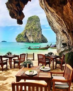 an instagram page with tables and chairs on the beach in front of some rocks