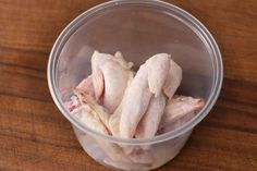 raw chicken in a plastic cup on a wooden table