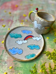 a small cup and saucer sitting on top of a table next to each other