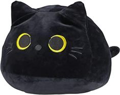 a black cat pillow with yellow eyes