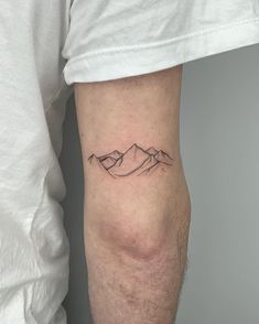 a man with a mountain tattoo on his arm