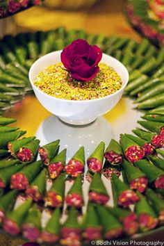 a white bowl filled with food and a red rose sitting on top of the bowl