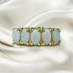 FREE SAME DAY SHIPPING & GIFT WRAPPING! A beautiful Antique victorian Five Stone Prong Opal Ring! This alluring 14kt gold antique ring holds 5 approximate 5x3.5mm opals along a stylish prong setting. The whites opal are simply mesmerizing, displaying an array of iridescent colors that flash and shimmer! A variety of colorful shades are included in the color play, almost seeming to glow from within. Completing the design are the sleek shoulders, which extend to a smooth gold band in the back. A s Victorian 14k Gold Opal Ring For Anniversary, Victorian Oval Opal Ring For Anniversary, Victorian Yellow Gold Opal Ring For Wedding, Victorian Yellow Gold Opal Wedding Ring, Gold Antique Ring, 14k Gold Opal Ring, Rings Birthstone, Gold Opal Ring, Rings Promise