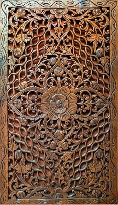 an intricate carved wooden panel with flowers and leaves