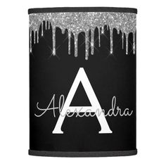 a black can cooler with silver glitter and the word alexandria in white letters on it