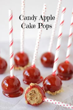 chocolate covered candy apples with red and white striped straws on top, lined up next to each other