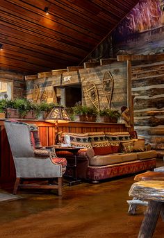 a living room filled with furniture next to a wooden wall covered in wood planks