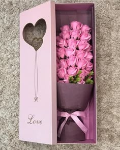 pink roses in a box with a heart shaped balloon on the top and love written on the side