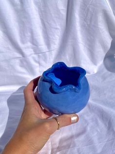 a person holding a blue vase in their hand