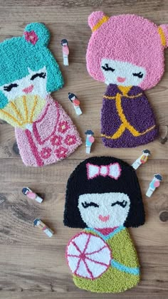 three crocheted dolls sitting on top of a wooden table