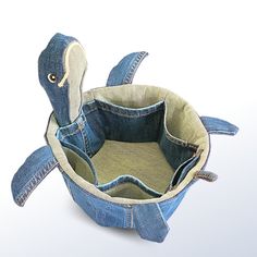 an empty denim tote bag that is shaped like a turtle with its head sticking out