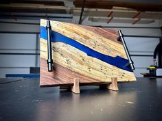 a wooden cutting board sitting on top of a table next to a pair of scissors