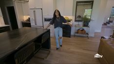 a woman standing in the middle of a kitchen