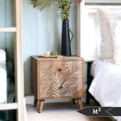 a wooden cabinet with flowers on it and a bed in the background