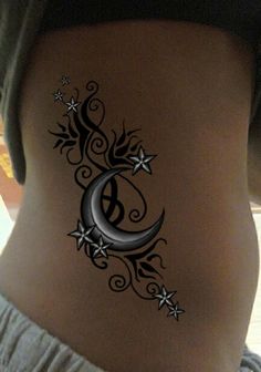 an image of a tattoo on the side of a woman's stomach with stars and crescent