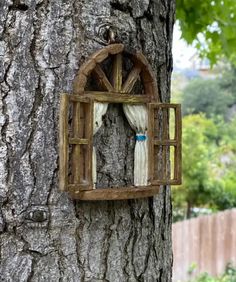 an old window hanging on the side of a tree