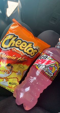 a bag of chips and a pink water bottle in the back seat of a car