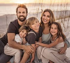 a family posing for a photo on the beach