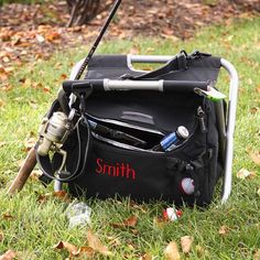 a black bag with fishing gear on it sitting in the grass