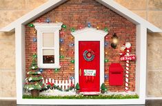 a small house with christmas decorations and lights on the front door, decorated for christmas