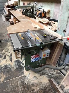 a table sawing on top of a piece of wood in a room filled with tools