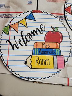 a welcome sign with an apple on top of books in front of a piece of lined paper