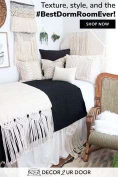 a bed with black and white sheets, pillows and fringes on the headboard