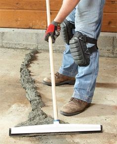 a man using a mop to clean concrete