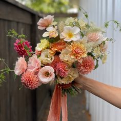 a person holding a bouquet of flowers in their hand