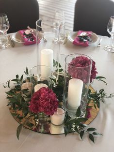 the centerpiece is surrounded by candles and flowers