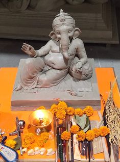 an elephant statue sitting on top of a table next to flowers and utensils