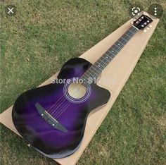 a purple ukulele sitting on top of a cardboard box