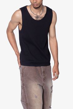 the Waffle Knit Tank is a 100% cotton tank is perfect as a base layer or worn alone. the tank features taping at the neck and arm openings, a flat hem, and is constructed in a ribbed material. details flat hem 100% ribbed cotton fabric Model is 6’0, 140 lbs and wears a size medium Black Sleeveless Top With Ribbed Neckline, Casual Ribbed Tank Top For Streetwear, Cotton Stretch Tank Top For Streetwear, Stretch Ribbed Tank Top For Streetwear, Black Cotton Muscle Tee For Layering, Casual Cotton Ribbed Tank Top, Casual Ribbed Cotton Tank Top, Casual Black Scoop Neck Vest, Black Cotton Muscle Tee For Everyday