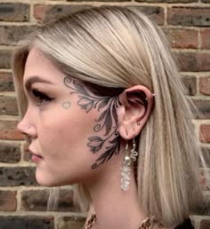 a woman with tattoos on her face and ear