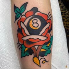 an old school style rose tattoo on the arm with pool eight - ball in it