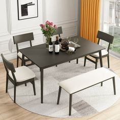 a dining room table with four chairs and a bench in front of the window, next to a potted plant