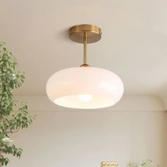 a living room with white walls and a round light fixture