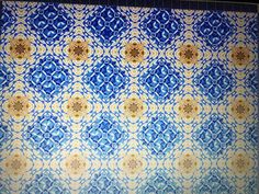 a blue and yellow wall with an intricate design on it